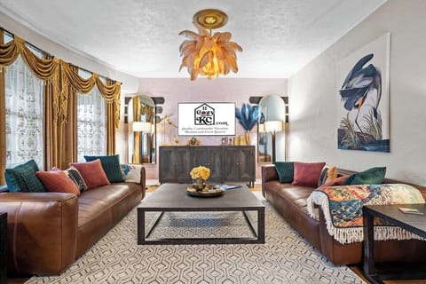 Step into The Luxe living room—an elegant, Art-Deco–inspired space with plush seating, designer lighting, and warm hardwood floors, perfect for relaxing after exploring Midtown KC and the streetcar line.
