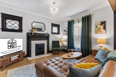 First Floor Living Room — A bright, stylish gathering space featuring a decorative fireplace, refined woodwork, and comfortable seating -perfect for unwinding after exploring walkable Westport and the West 39th Street dining + entertainment districts