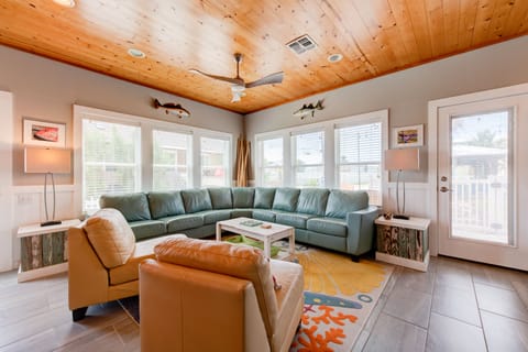 Your spacious living room features comfortable seating, a stunning wood-paneled ceiling, and bright windows that flood the space with natural light.