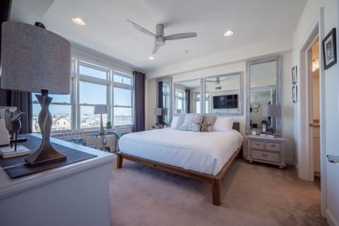 The master suite offers designer decor, king bed, and stunning bay views.