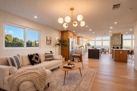 Bright open-plan living, island kitchen, and wall-to-wall view windows.