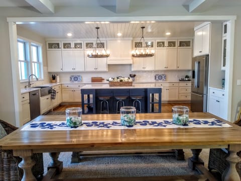 Generous kitchen with large blue island and quartz top.
