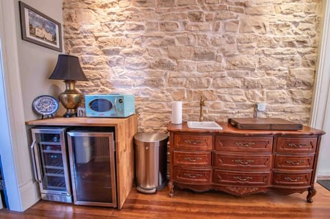 Enjoy our glossy refrigerator, stainless-steel wine cooler, and a wooden table