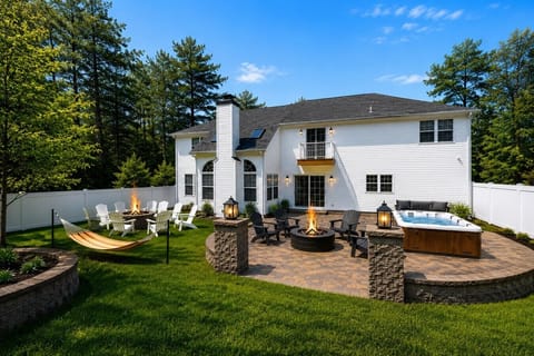[Rear Exterior Patio]  “Spacious backyard featuring a private hot tub, two fire pits, outdoor seating, and a fully fenced yard.”