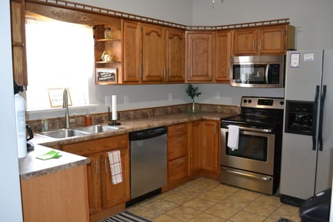 kitchen stocked with plates, cups, utensils and cooking ware.