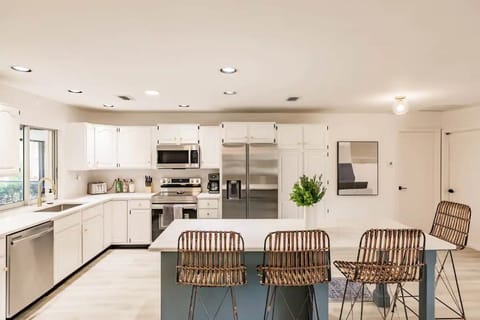 Stocked kitchen w/ window that access outdoor pool bar.