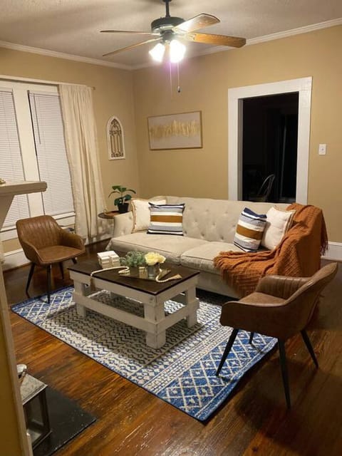 Spacious living room with ceiling fan, comfortable seating for 4+, and beautiful original hardwood floors