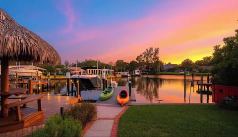 Golden sunset views over the water with a private dock, tiki hut, and kayaks ready to launch. Watch boats drift by as the sky glows pink and orange—perfect for evening cocktails, paddling at dusk, or soaking in the ultimate waterfront vibe.