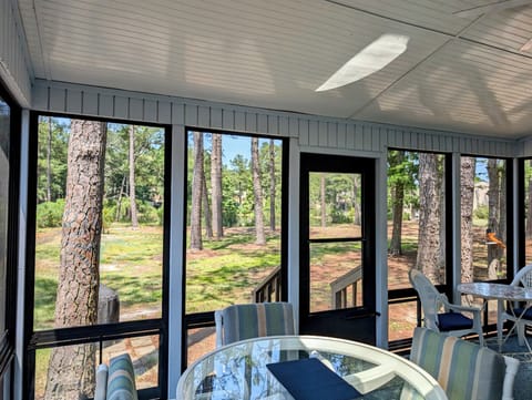 745A Clubhouse Lane - Sunroom - Bright and airy sunroom at 745A Clubhouse Lane, featuring large windows with tranquil, wooded views and comfortable indoor dining seating.