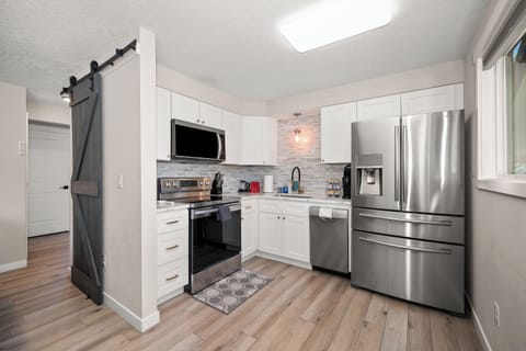 Bright modern kitchen with stainless appliances and stylish barn door