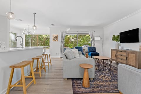 Living room with open concept to kitchen, dining and sliders to backyard