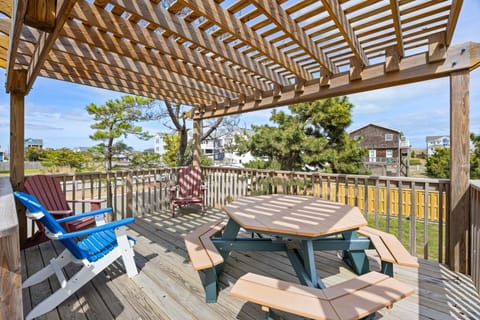 The shaded pergola creates the perfect outdoor retreat for relaxing after a day at the beach.