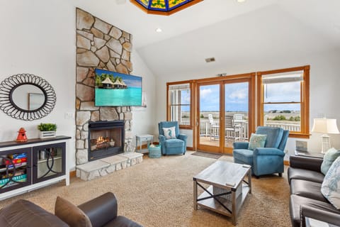 Relax in the spacious Living Area with a fireplace, flat-screen TV, and deck access. (Please Note: Fireplace is not for guest use)
