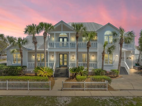 This stately beachside home features new amenities, beautiful porches and palms