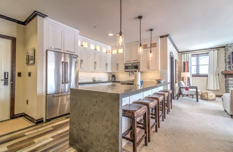 - Large modern kitchen with bar seating, pendant lights, and sleek design - Stainless appliances and spacious counters offer perfect functionality - Great for après-ski meals, family cooking, and comfortable mountain stays