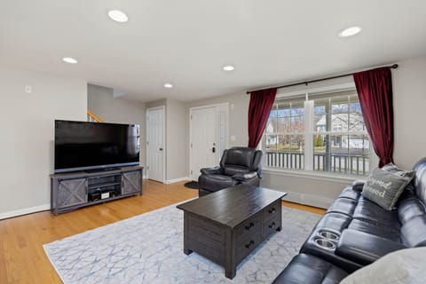 Living room with oversized leather reclining couch, recliner and 60" smart tv