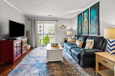 Living area with sectional sofa and balcony doors at Sandwedge 206, a 2-bedroom Ocean Drive condo from Thomas Beach Vacations