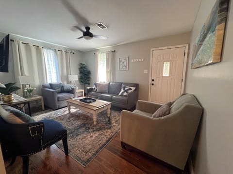 Living room with smart TV, games, books, puzzles, overhead fan