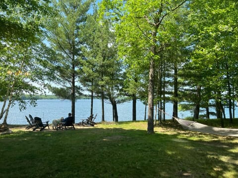This is your view from your bedroom the lake, front yard, hammock & fire pit.