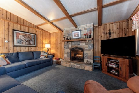 Spacious upstairs living room with stone fireplace and comfy seating.