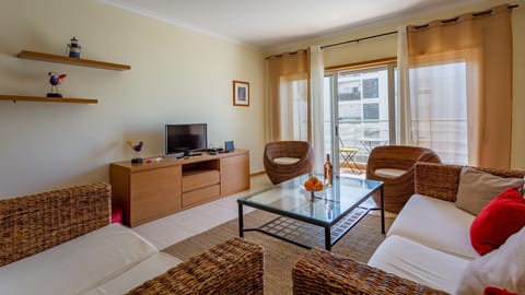 A lovely living area with a comfy sofa, cable TV, and balcony access #cozy #home #comfort #decoration