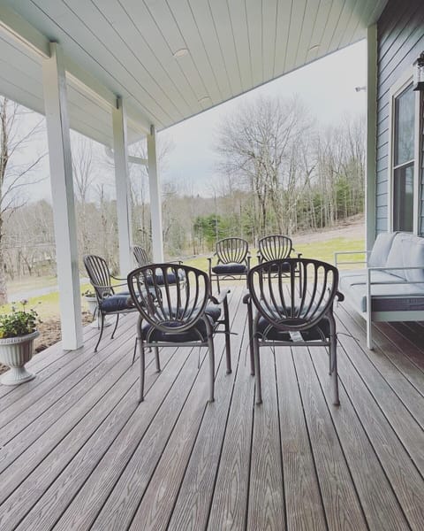 Enjoy the front porch, furnished with outdoor seating and a 12’ dining table. 