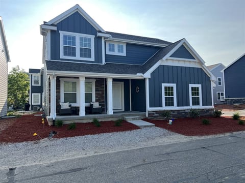Welcoming front porch, crisp blue siding, and fresh landscaping