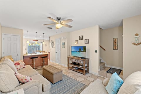 Cozy living area with TV, seating, and open kitchen for relaxing or movies.