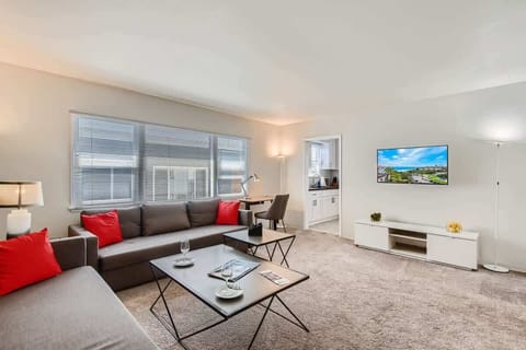 Sophisticated living room design with a work desk area, a sofa that opens to a full-size bed, 50” Smart TV, All of our TVs are smart TVs, so you can easily log into your own favorite streaming apps. Beautiful decor, and much more.