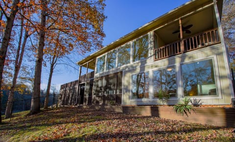 Exterior lake front view with a gentle slope to the water and three decks