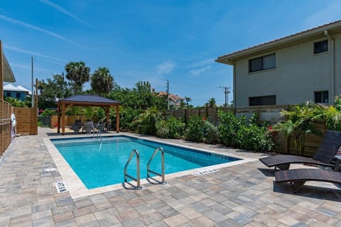 Relax by the private pool with shaded seating and tropical landscaping.