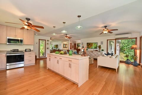 Gather in a stylish open layout featuring tropical décor and natural light.