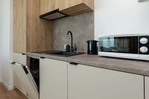 Functional kitchen with dishwasher and microwave. The whole creates a comfortable space for preparing home-cooked meals.