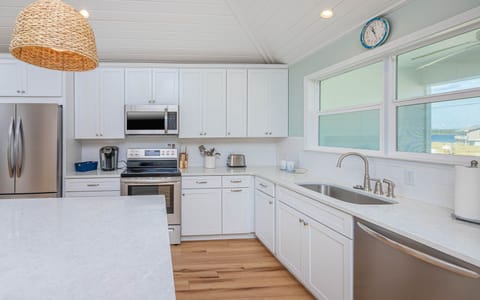 The kitchen features a Keurig, toaster, and an overall sleek and spacious design, perfect for meal prep and gatherings