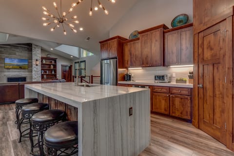 - Modern kitchen with marble waterfall island design  
- Pendant lighting creates a stylish cooking space  
- Stainless steel appliances with wood cabinetry