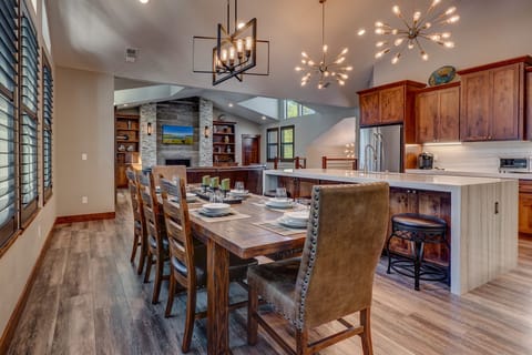 - Dining room with large rustic table and seating  
- Overlooks kitchen and living area with fireplace  
- Open-concept design for family meals and gatherings