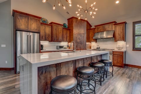 - Kitchen with marble island and modern lighting  
- Stainless steel appliances and rich wood cabinets  
- Open layout ideal for cooking and gathering