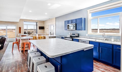 Dining area accommodates 20+ guests, with a big kitchen island and 4 tables