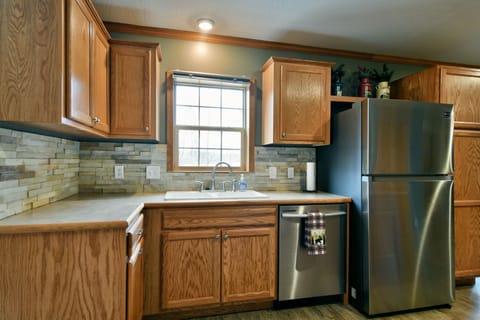 Kitchen skink with view of the backyard fire pit and the lake, and dishwasher. 