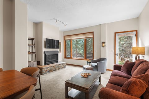 Cozy living room with a fireplace and picture-perfect forest views — your Telluride retreat starts here.