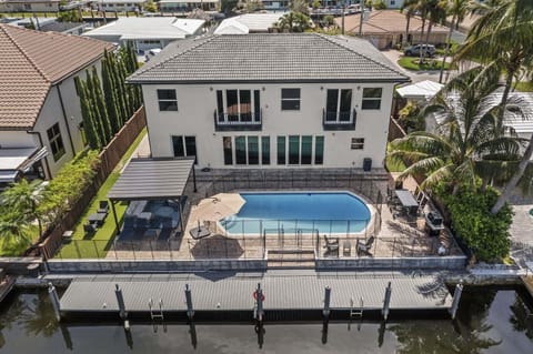 This large family home located directly on the water has a heated pool, boat dock and open plan living spaces.