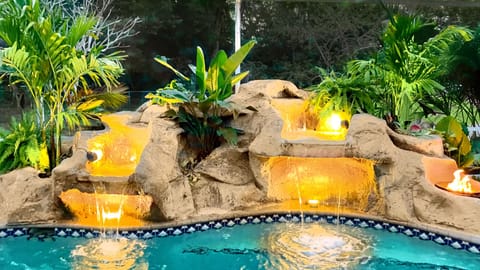Lighted waterfall with fire feature gives a tropical oasis vibe!