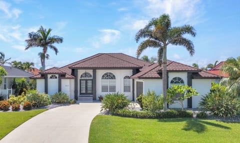 SPACIOUS HOME HAS AMAZING CURB APPEAL WITH ABUNDANT TROPICAL PLANTS AND TREES
