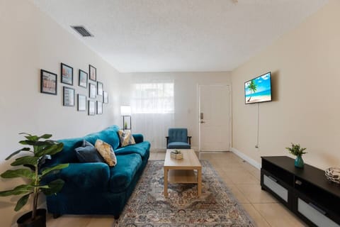 Charming living room with a comfortable blue sofa, perfect for unwinding while watching your favorite shows on the smart TV. A stylish blend of vintage decor and modern comfort.