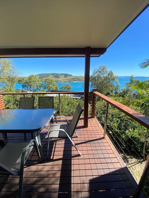 Private ocean-view balcony with outdoor dining and sunset views