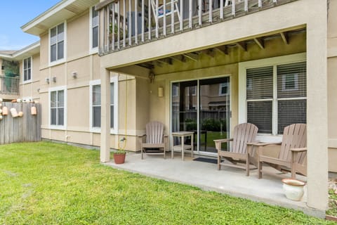 Modern two-story vacation rental featuring a covered patio with comfortable seating and private yard space.