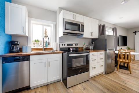Sleek kitchen w/ stainless steel appliances, white cabinetry & plenty of counter space for easy cooking.