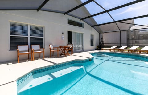 Enjoy the private pool area with sun loungers, outdoor table, and chairs.