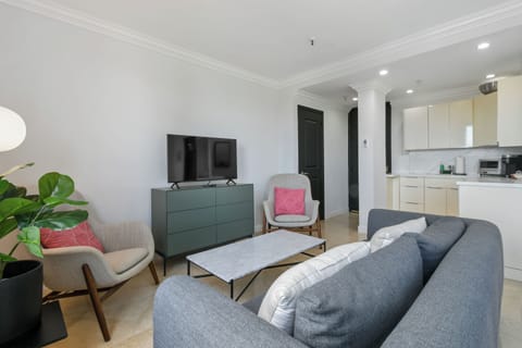 Spacious studio suite with a king-size bed, modern decor, seating area, and natural light