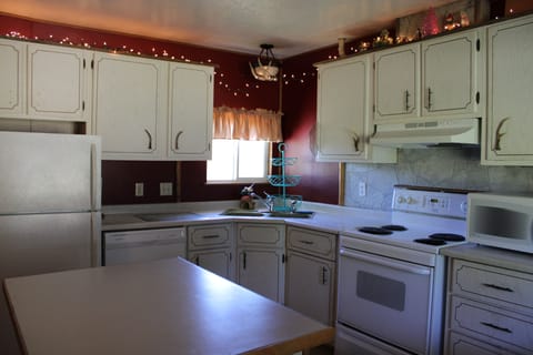 Full kitchen with refrigerator, dishwasher, stove, coffee maker, and microwave.
